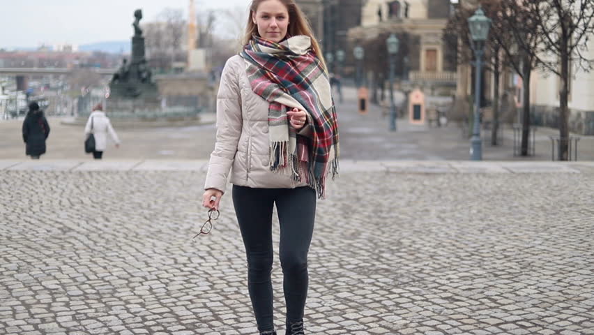 Portrait young attractive smile woman look at camera at city center feel happy fashion girl summer face technology sun beautiful slow motion street
