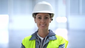 Female construction worker smiling at camera in warehouse
