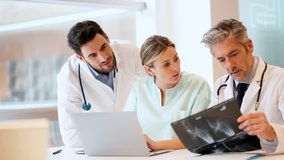 Doctors and nurse looking at X-Ray in hospital office