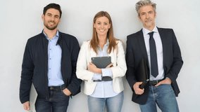Mixed business team smiling at camera on grey background