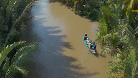 Aerial view of mangroves forest in Mekong Delta. Vietanmese man padlles on the river.