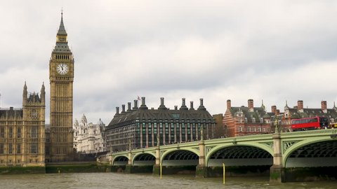 4K video of red bus, traffic and people on Westminster Bridge over the River Thames next to Big Ben and The Houses of Parliament, London, England