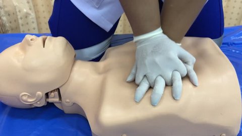 CPR training medical procedure demonstrating chest compressions on CPR doll.