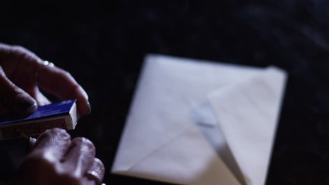 Hand close up melting wax onto a letter. Sealing a letter the old fashioned way