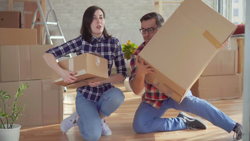 tired young couple with laptop on the background of boxes for moving Royalty-Free Stock Footage #1026519854