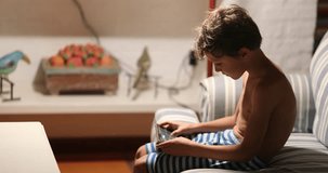 Candid little boy in front of cellphone device indoors at home