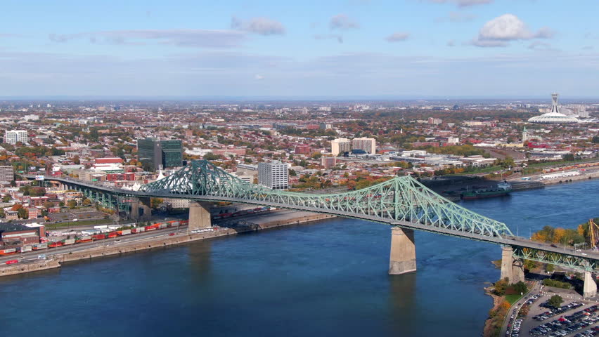 Montreal, Quebec, Canada, aerial view of Montreal cityscape showing architectural landmarks Jacques Cartier bridge and Olympic Stadium during Fall season.
