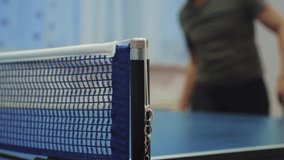 table tennis serve concept. slow motion video. blurred focus on the grid. man playing training lifestyle serves ball in table tennis the sport active