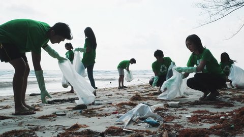 Asian group volunteer member cleaning summer beach and keeping garbage together in cleaning day. Concept of waste environment, recycle, ecology, pollution and volunteer. 4k resolution.