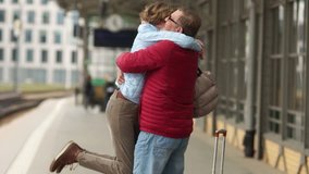 Beautiful mature retired couple met at the train station after a separation. A man hugs a woman and turns her in his arms - Powered by Shutterstock - Get 15% off with code: PIKWIZARD15