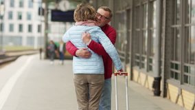 A retired man meets a woman on the train platform. Couple embraces and kisses - Powered by Shutterstock - Get 15% off with code: PIKWIZARD15