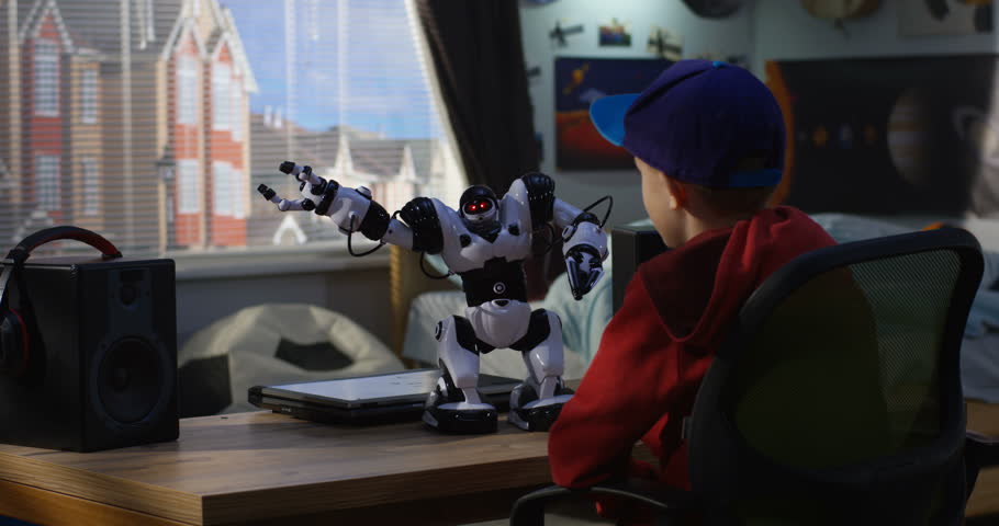 Medium shot of a boy controlling his toy robot with exoskeleton gloves