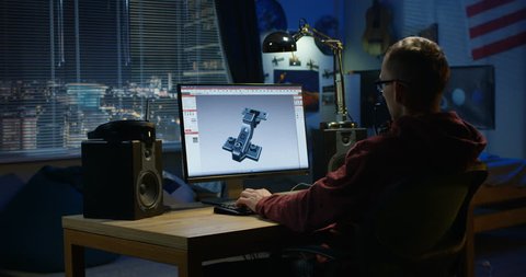 Medium shot of a man using a computer to design a hinge at home