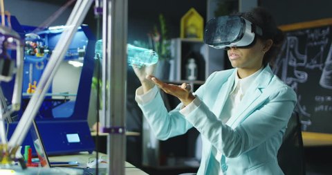 Medium shot of a female scientist using VR headset to design an object