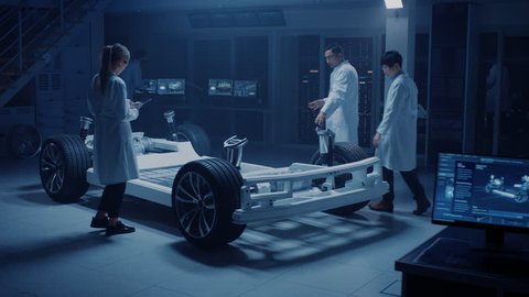 Team of Automotive Engineers and Scientists Discussing, Designing and Working on Electric Car Platform Chassis Prototype. Using 3D CAD Software, Analysing Efficiency. Shot on 8K RED Camera.