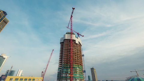 Frankfurt, Hesse/Germany – March 1 2018, Grand Tower under construction timelapse, residential building, elevators and material lifts going up and down, red cranes are moving
