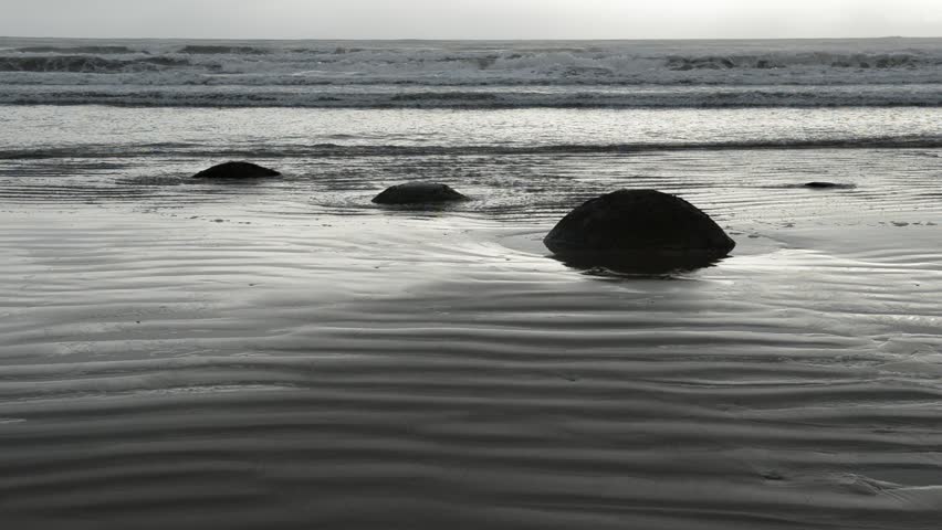 Moeraki boulders, ocean surf and ripple on an empty New Zealand beach