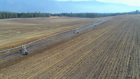 Aerial view of irrigation sprinkles used in harvested field on a sunny day 