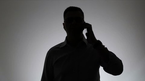 Silhouette of a man on a white background. Portrait of a businessman silhouette talking on the phone