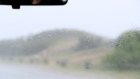 Windshield wipers in motion driving on road in the rain. - Powered by Shutterstock - Get 15% off with code: PIKWIZARD15
