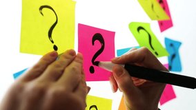 Businesswoman writing question marks on colorful sticky note paper on office whiteboard - Powered by Shutterstock - Get 15% off with code: PIKWIZARD15