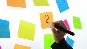 Businesswoman writing question marks on colorful sticky note paper on office whiteboard - Powered by Shutterstock - Get 15% off with code: PIKWIZARD15