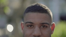 Close-up short of young Afro-American male eyes in park looking at camera, smiling. Front view. Lifestyle concept concept 
