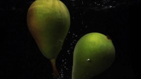 Two pears falls into the water with splashes and bubbles in slow motion. - Powered by Shutterstock - Get 15% off with code: PIKWIZARD15