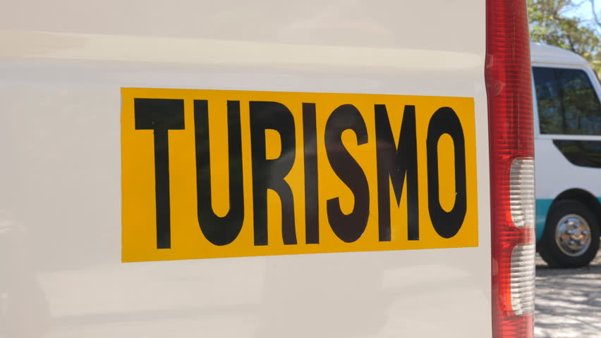 TURISMO sign on side of bus. Tourist transport. Bus in the background. Tourism in Costa Rica. Handheld shot with stabilized camera.