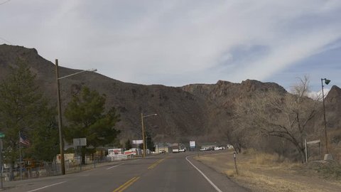 CALIENTE, NEVADA - MARCH 1, 2019: Drive Plate-View Forward-Passing out of the town of Caliente, Nevada-Rugged hills on the outskirts of town-POV