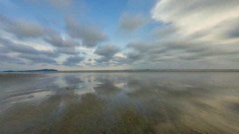 High quality time lapse at the beach with ultra smooth motion blur reflection on the shore and clouds movement.