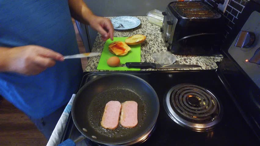 Single man making breakfast with cheese eggs and spam Royalty-Free Stock Footage #1026587345