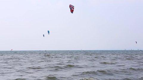 Many kitesurfers in action on a windy day. The view from the beach.