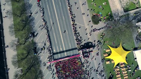 Aerial view from drone on crowd of people who is starting their run on marathon event.