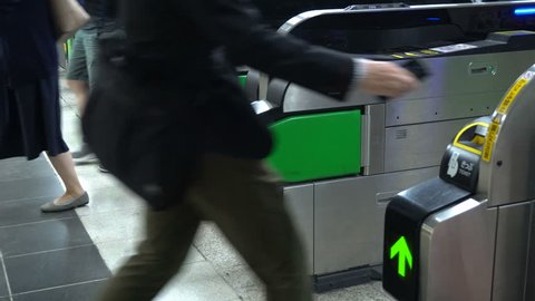 Anonymous Commuters Passing Through Ticket Gate At Subway Station