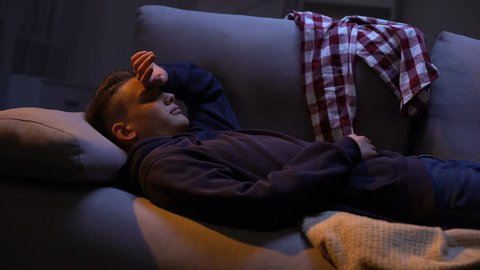 Young male waking up after student party in strange place, alcohol addiction