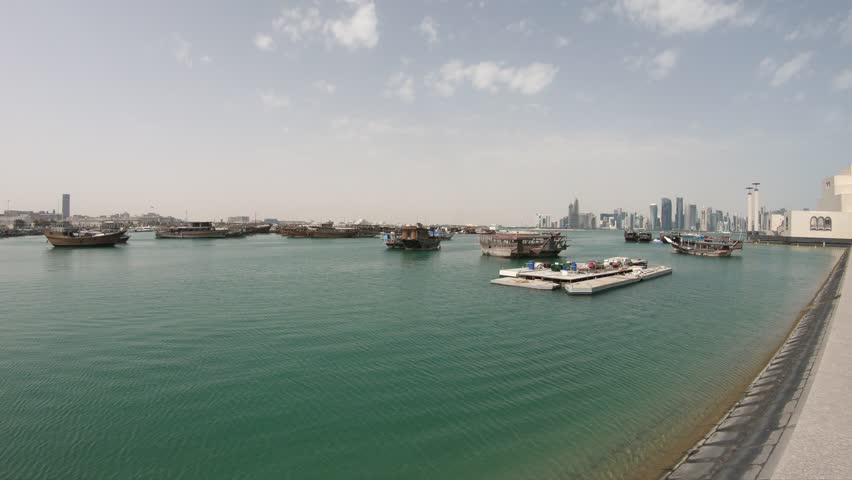 Doha seafront with palm trees and West Bay skyline along Corniche in Qatari capital with Dhow Harbour in a sunny day. Doha in Qatar. Middle East, Arabian Peninsula, Persian Gulf.