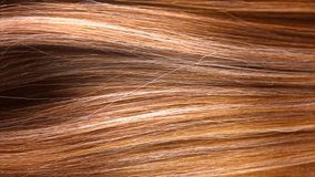 Hair. Beautiful healthy long smooth flowing brown coloring hair close-up texture. Dyed straight hair background, coloring, extensions, cure, treatment concept. Haircare. Slow motion 4K UHD video