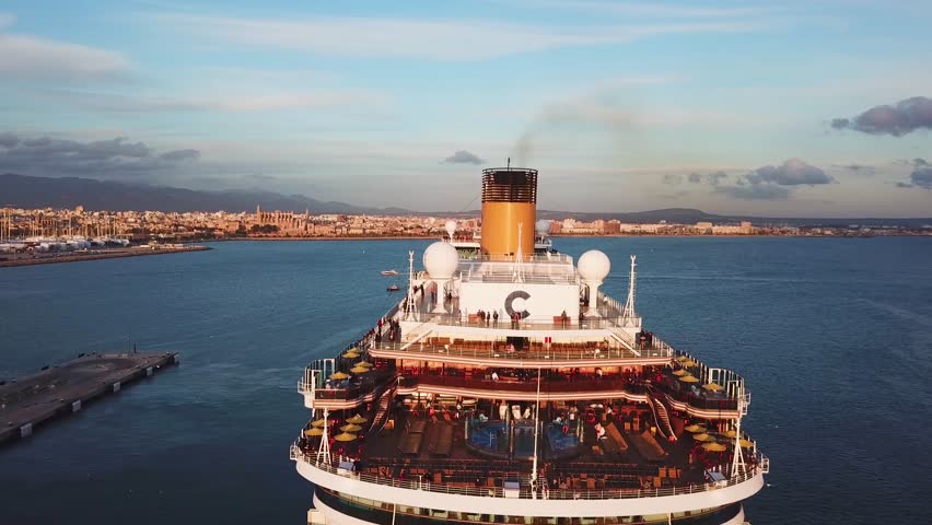 Cruise ship at harbor. Stock. Aerial view of beautiful large white ship at sunset. Colorful landscape with boats in marina bay, sea, colorful sky. Top view from drone of yacht. Luxury cruise