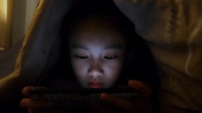 Close up of cute asian girl using smartphone ,Young teenage boy playing games on mobile phone.