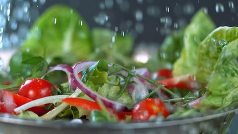 Water falling to fresh salad in super slow motion.