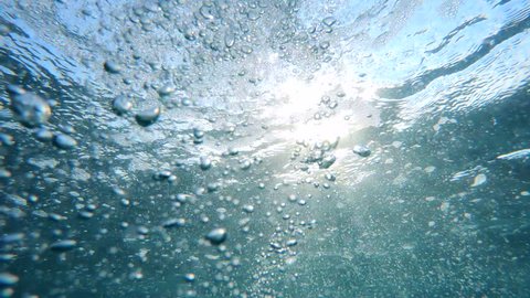 Underwater Bubbles with sunlight through water surface, natural slow motion underwater scene
