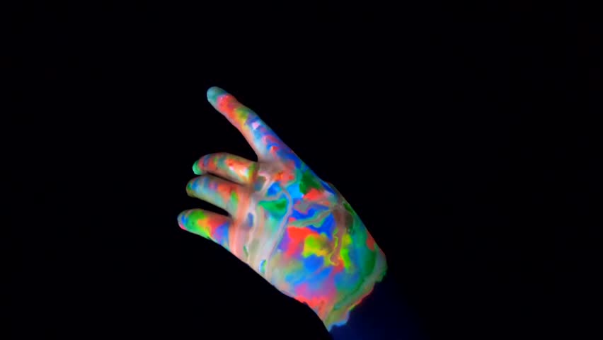 
Painted hand with UV fluorescent colors on a black background.