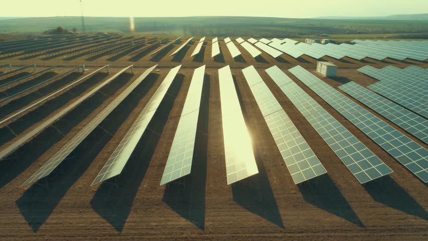 Solar panel produces green, environmentaly friendly energy from the setting sun. Aerial view from drone. Landscape picture of a solar plant that is located inside a valley Royalty-Free Stock Footage #1026661490