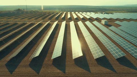 Solar panel produces green, environmentaly friendly energy from the setting sun. Aerial view from drone. Landscape picture of a solar plant that is located inside a valley