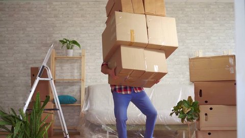 Man with large boxes in his hands falls on the sofa