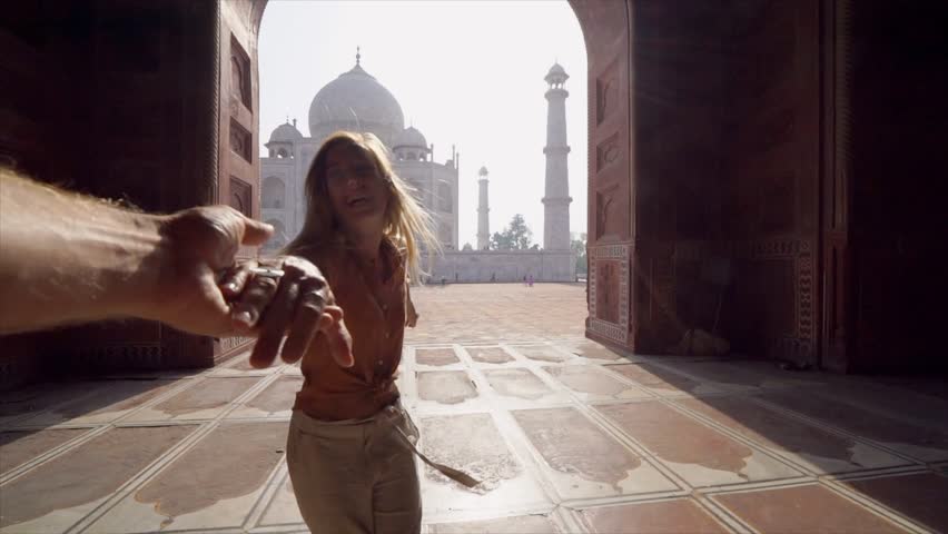 Follow me to the Taj Mahal, India. Female tourist leading boyfriend to there magnificent famous Mausoleum in Agra. People travel concept - Girl holding man hand at sunrise traveling together- Slow mo | Shutterstock HD Video #1026673967