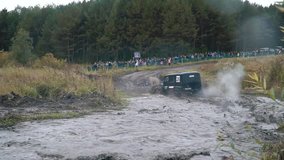 Close-up of Russian suvs participating in a off-road racing and crossing the large puddles. Clip. Russian roads
