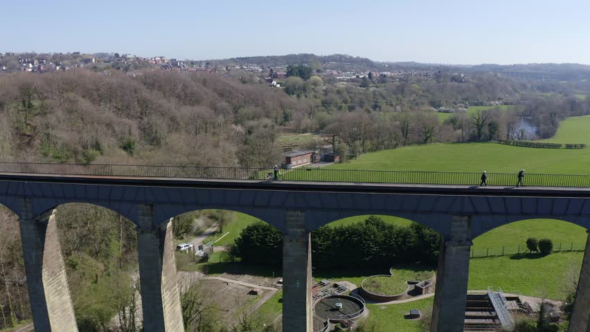 A cyclist admires the beautiful view of the  Narrow Boat canal route called the Pontcysyllte Aqueduct famously designed by Thomas Telford,  located in the beautiful Welsh countryside, bridge 