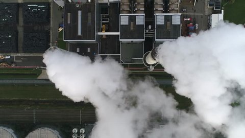 Aerial top down view of coal fired power plant thermal station this electricity production provides about 32 percent of consumed electricity in the United States showing thick white flue exhaust 4k
